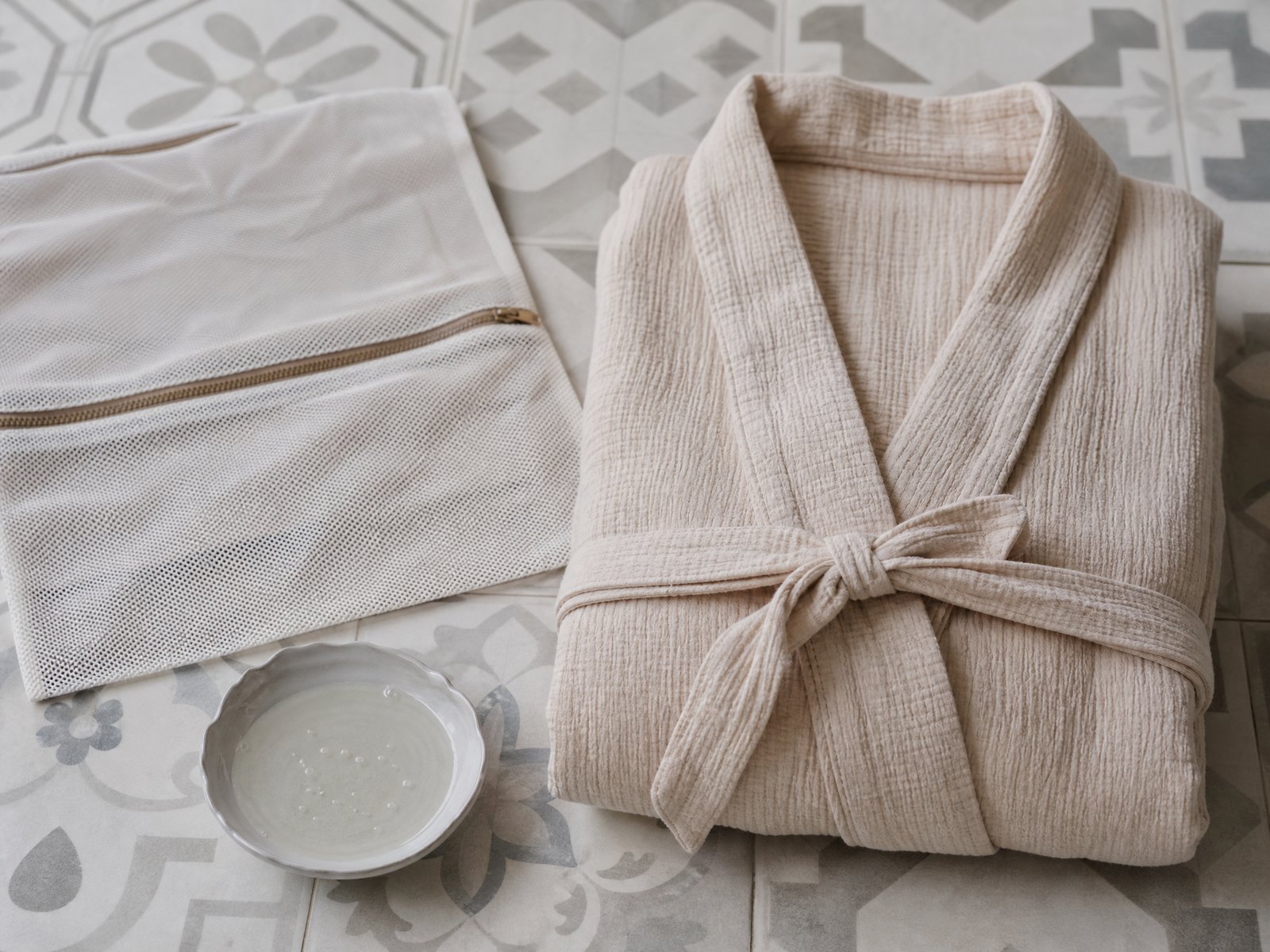 A folded lambswool jumper beside wool detergent flakes and a garment brush